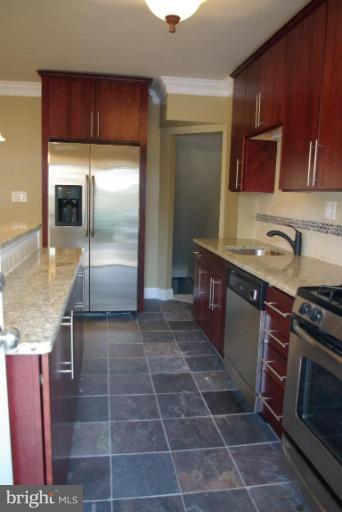 4676 Marble Hall Road Baltimore, MD 21239 - Photo 3 of 20 a kitchen with kitchen island granite countertop a sink stove and refrigerator