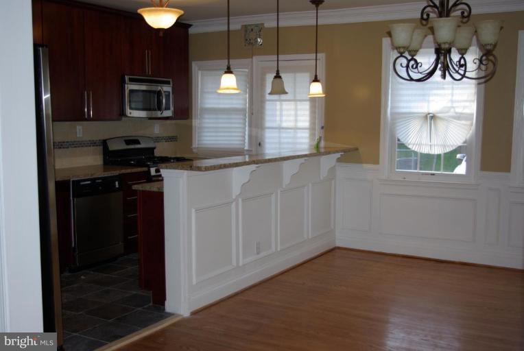 4676 Marble Hall Road Baltimore, MD 21239 - Photo 6 of 20 a kitchen with granite countertop a stove and a microwave
