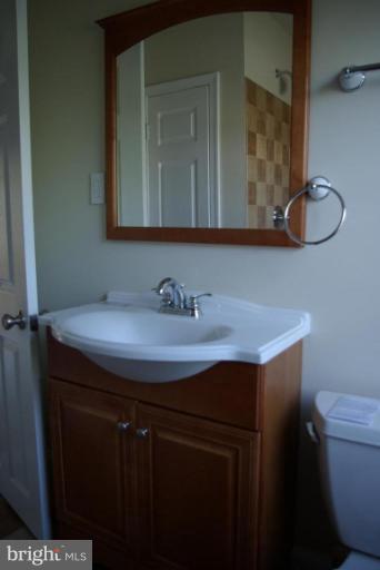 4676 Marble Hall Road Baltimore, MD 21239 - Photo 8 of 20 a bathroom with a sink a toilet and mirror
