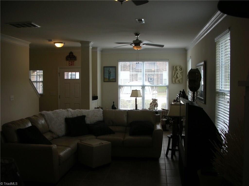 3772 Shadow Ridge Drive High Point, NC 27265 - Photo 11 of 27 View of living room from the breakfast area. Living room has 2 ceiling fans with lights, crown molding, 4 windows and tile flooring.