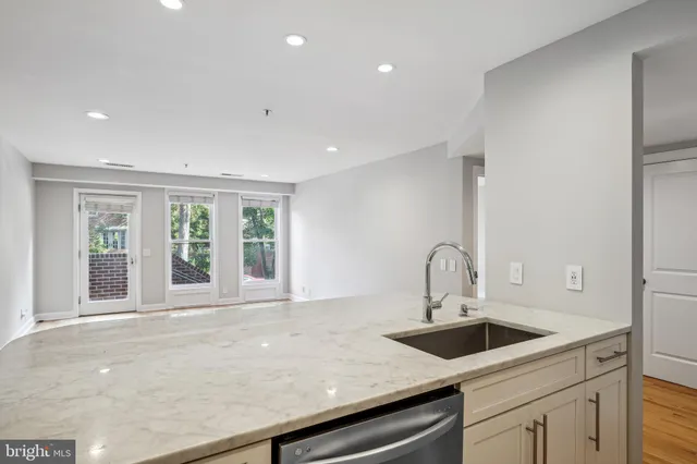 a kitchen with a sink and wooden floor