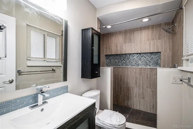 a bathroom with a sink a toilet a mirror and shower