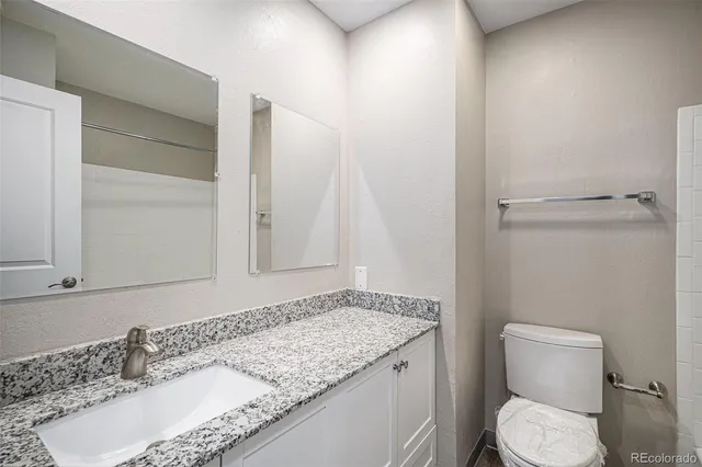 a bathroom with a granite countertop sink and a mirror