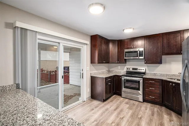 a kitchen with stainless steel appliances granite countertop a stove top oven and sink