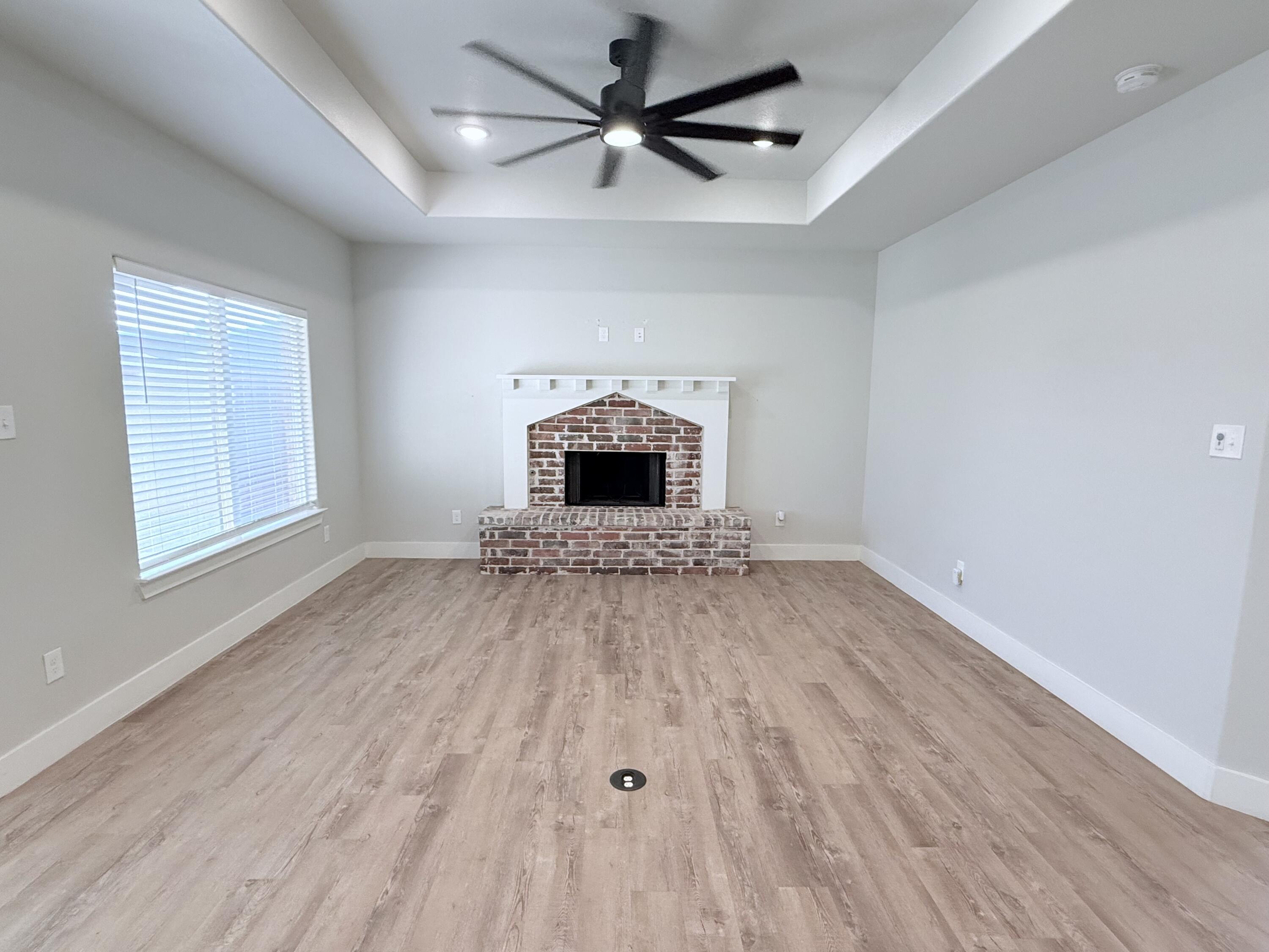 2915 137th Street Lubbock, TX 79423 - Photo 11 of 40 wooden floor fireplace and windows in an empty room