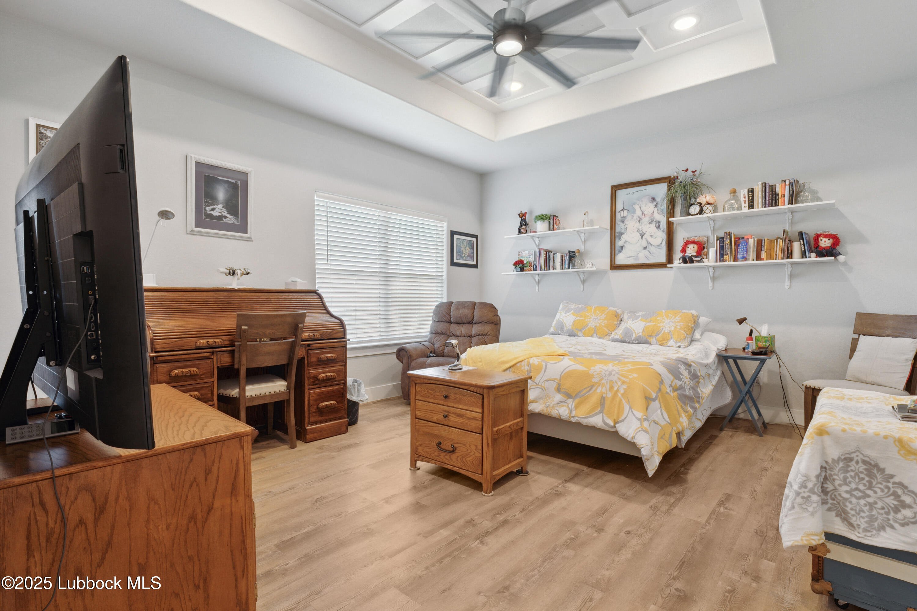 2915 137th Street Lubbock, TX 79423 - Photo 28 of 40 a bedroom with a bed and a flat tv screen on dresser