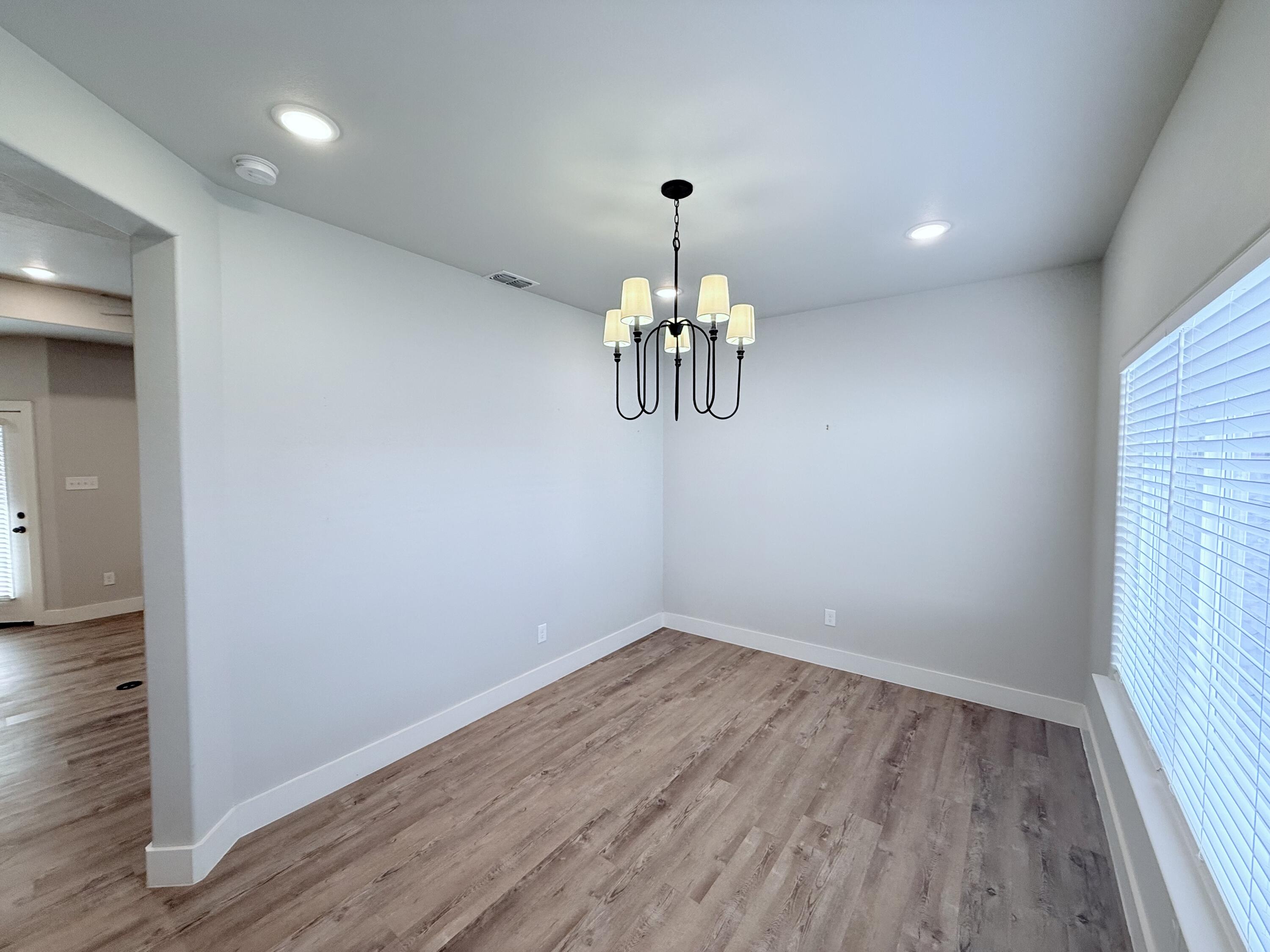 2915 137th Street Lubbock, TX 79423 - Photo 6 of 40 a view of a room with a chandelier and wooden floor