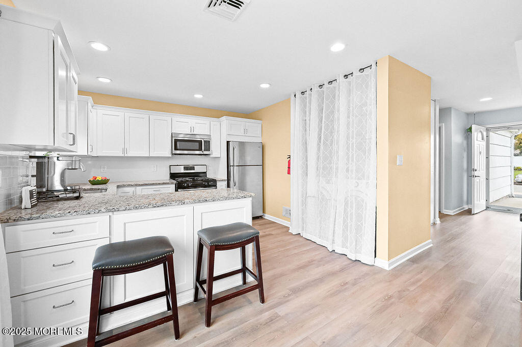 9 Tralee Road Hazlet, NJ 07730 - Photo 14 of 40 a kitchen with stainless steel appliances granite countertop a white cabinets and a stove top oven