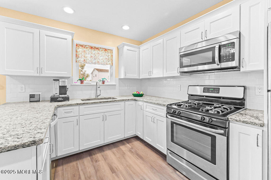 9 Tralee Road Hazlet, NJ 07730 - Photo 17 of 40 a kitchen with stainless steel appliances white cabinets granite counter tops and a window