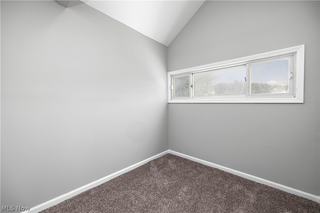 7030 Pearl Road Cleveland, OH 44130 - Photo 26 of 34 Empty room featuring carpet flooring and lofted ceiling