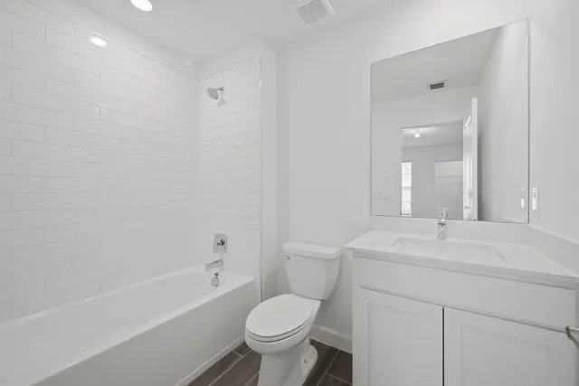 a bathroom with a sink toilet vanity and shower