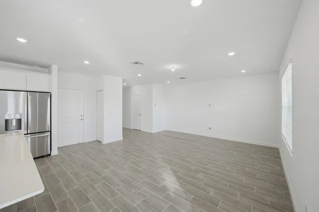 an empty room with closet and windows