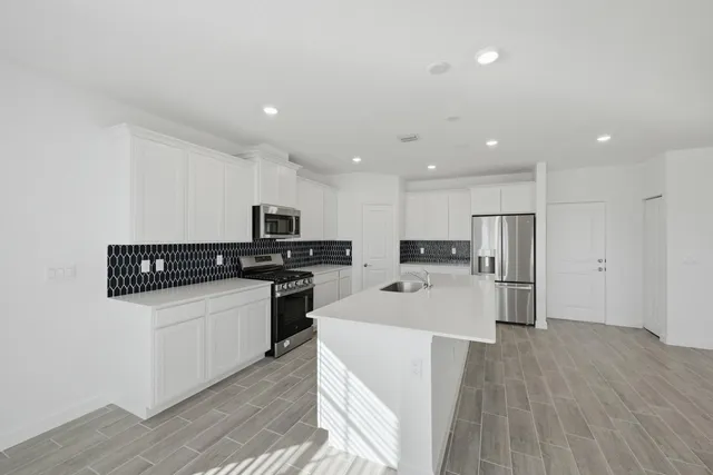 a kitchen with stainless steel appliances kitchen island sink stove and refrigerator
