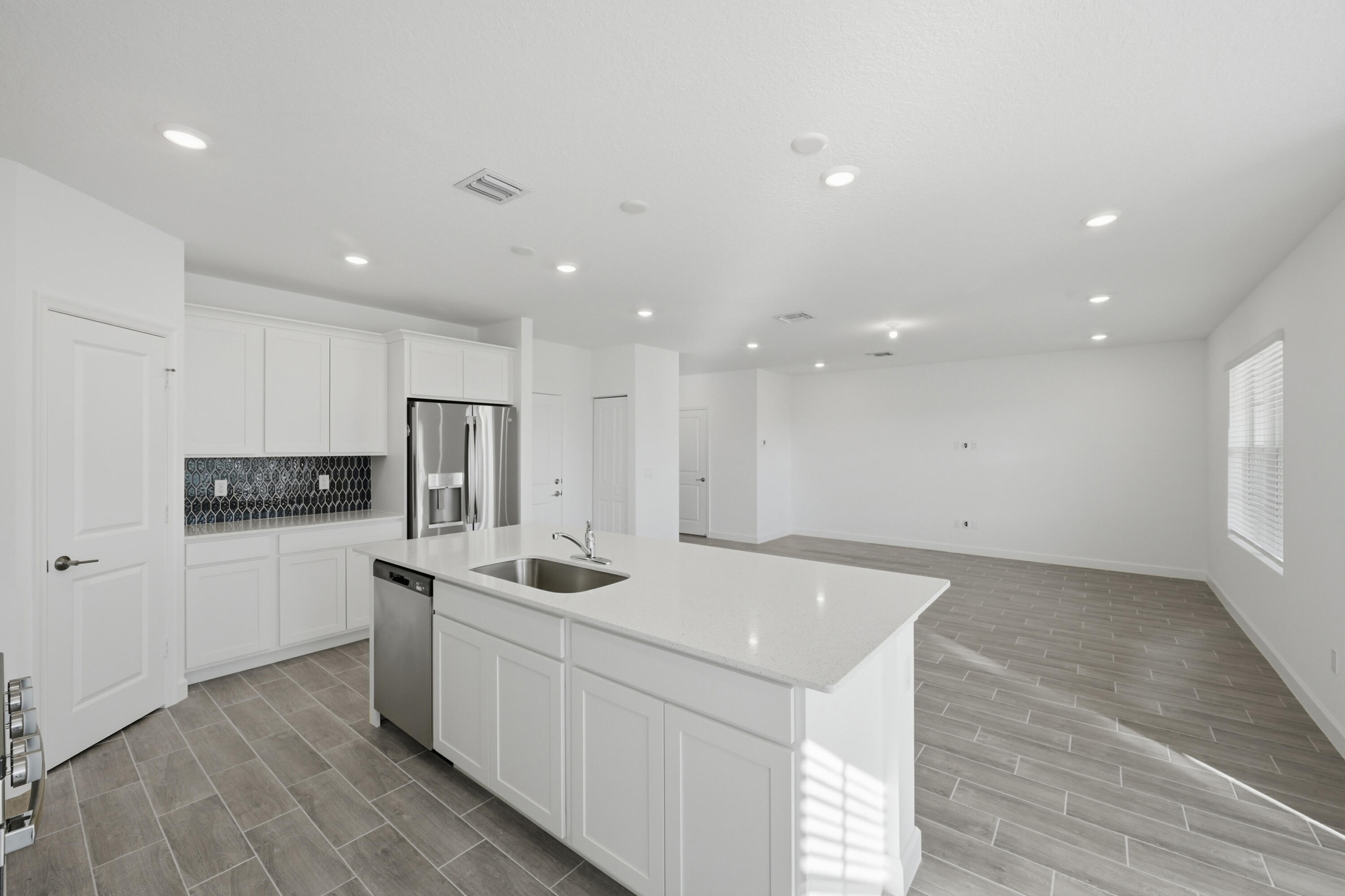 19568 Whispering Creek Road Loxahatchee, FL 33470 - Photo 10 of 30 a kitchen with a sink a refrigerator and white cabinets
