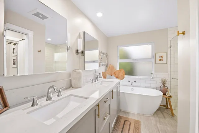 a bathroom with a double vanity sink toilet mirror and bathtub
