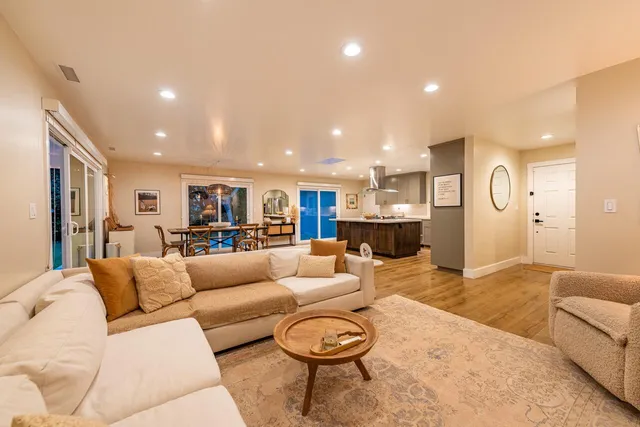 a dining room with wooden floor glass table and chairs