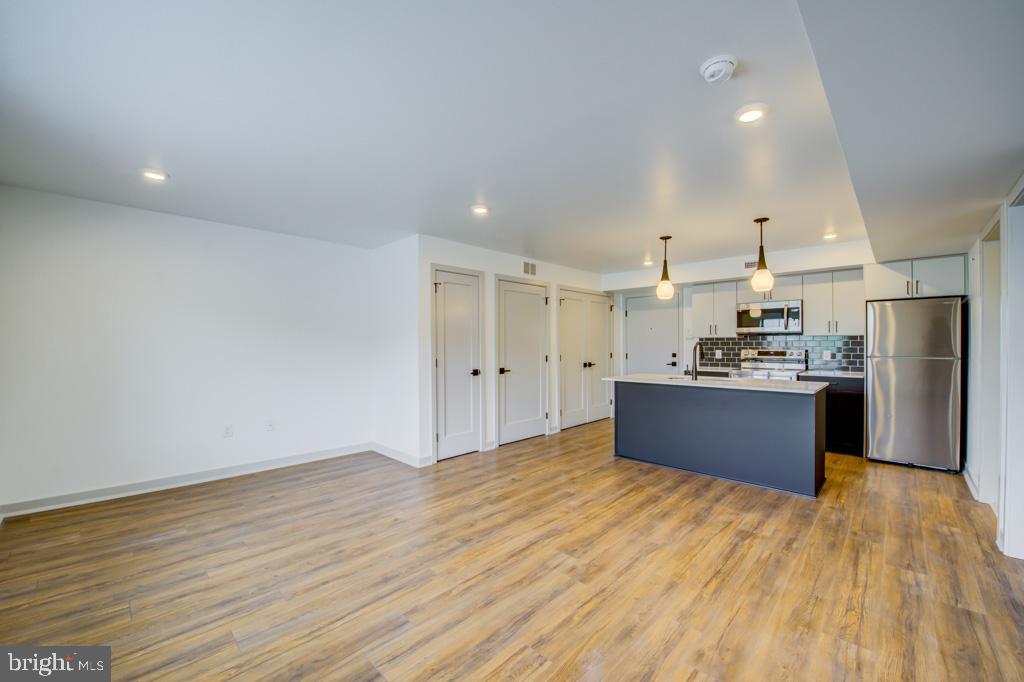 5001 Umbria Street, Unit P607 Philadelphia, PA 19128 - Photo 3 of 10 a large kitchen with stainless steel appliances kitchen island a large counter top and a wooden floors