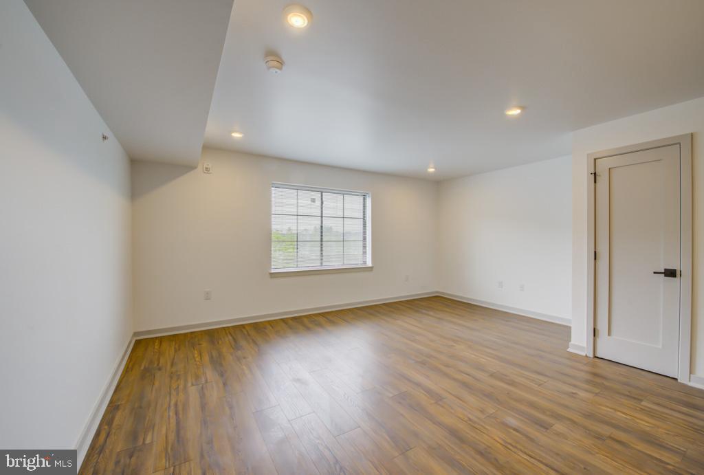 5001 Umbria Street, Unit P607 Philadelphia, PA 19128 - Photo 4 of 10 an empty room with wooden floor and windows