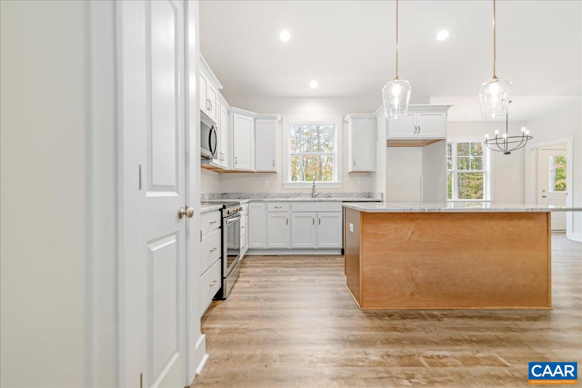6443 Bremo Road Bremo Bluff, VA 23022 - Photo 10 of 31 a large kitchen with stainless steel appliances granite countertop a stove a sink and white cabinets with wooden floor