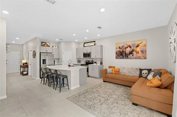 a living room with furniture and kitchen view