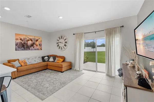 a living room with furniture a flat screen tv and a window