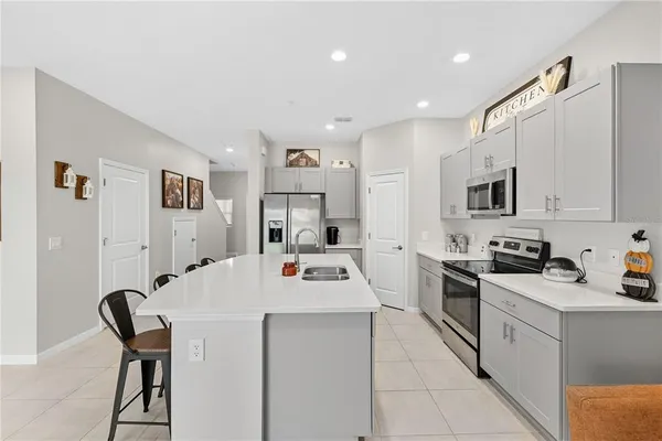 a kitchen with a sink a stove and chairs
