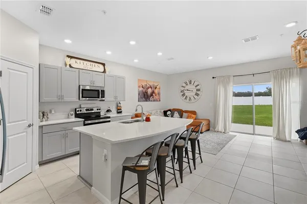 a kitchen with stainless steel appliances a stove a sink a microwave and a refrigerator