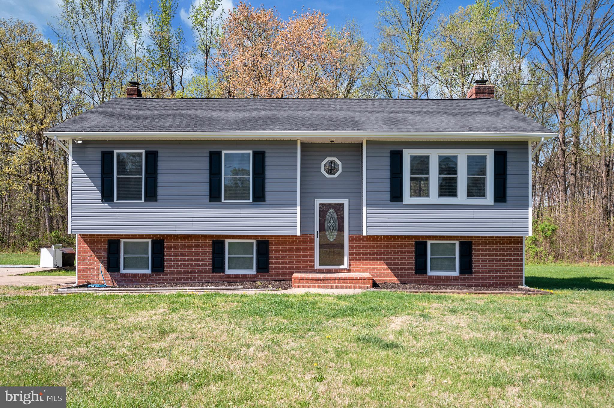 13452 Post Oak Road Spotsylvania, VA 22551 - Photo 7 of 56 a view of a brick house with a large window and large tree
