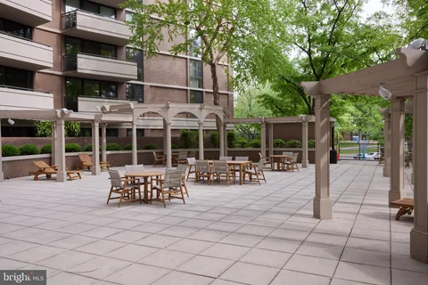 a view of a patio with dining table and chairs with a large tree