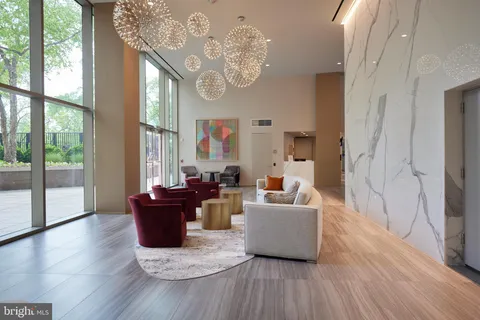 a living room with furniture large window and wooden floor