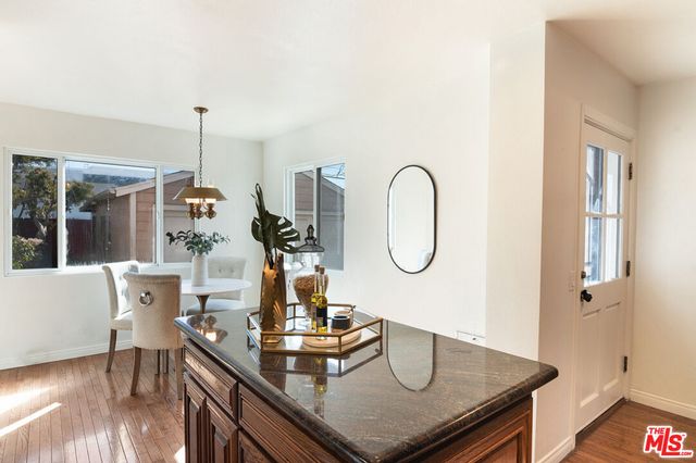 a kitchen with a table chairs and wooden floor