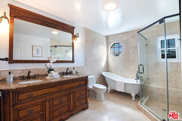 a bathroom with a double vanity sink a toilet and a mirror