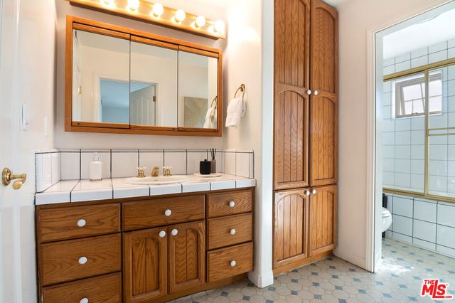 a bathroom with a sink a mirror and a shower