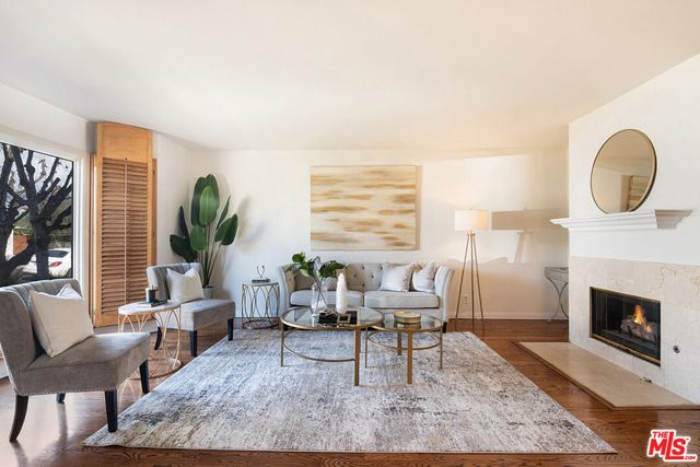 a living room with furniture a fireplace and a large window
