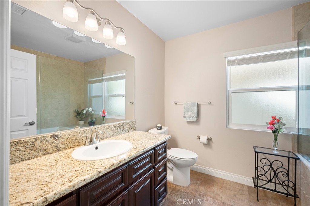 724 San Luis Rey Road Arcadia, CA 91007 - Photo 9 of 15 a bathroom with a granite countertop sink a toilet and a mirror