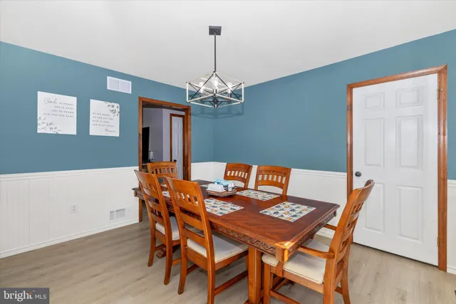 a view of a dining room with furniture wooden floor and chandelier