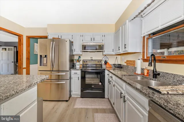 a kitchen with granite countertop a refrigerator stove and oven
