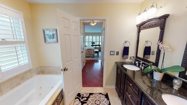 a bathroom with a bathtub sink and mirror with bathtub