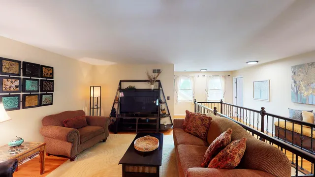 a living room with furniture a rug and a book shelf