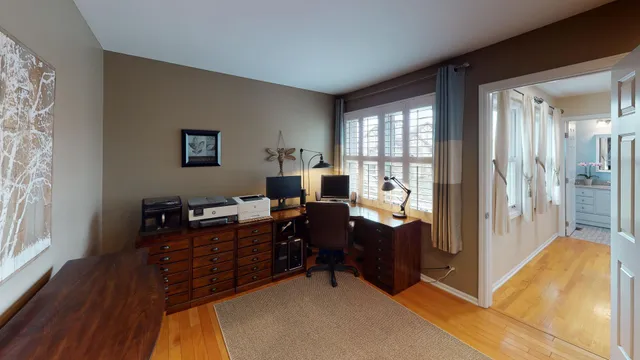 a view of a workspace with furniture and a window