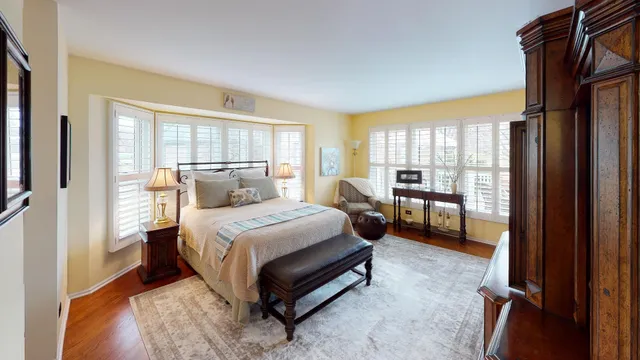 a bedroom with a bed and a large window