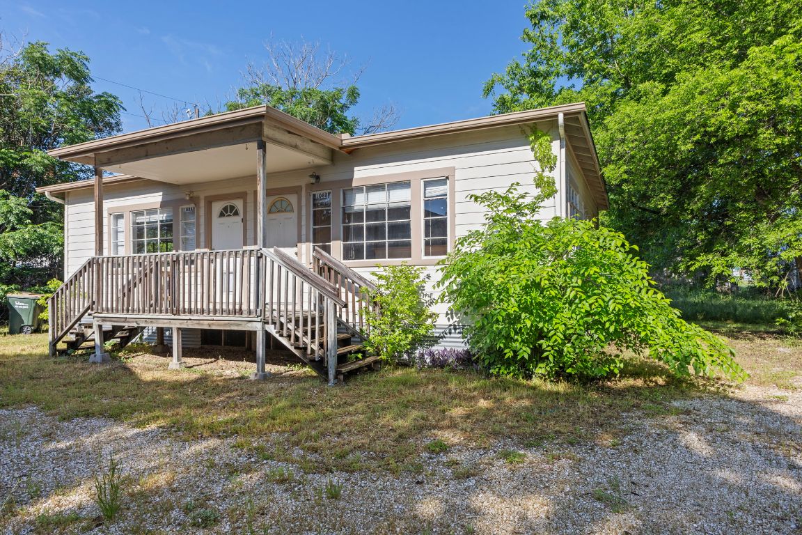 a view of a house with a yard and potted plants