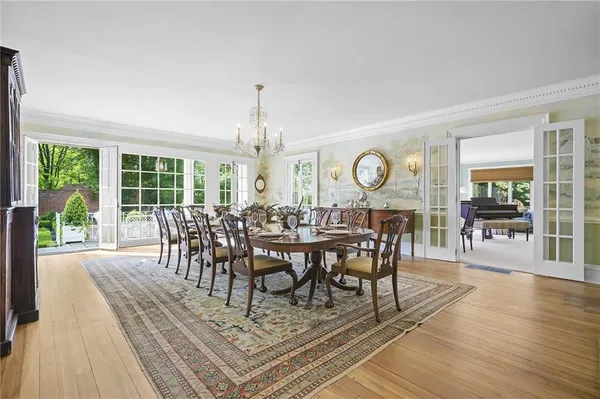 a view of a dining room with furniture a chandelier and large windows