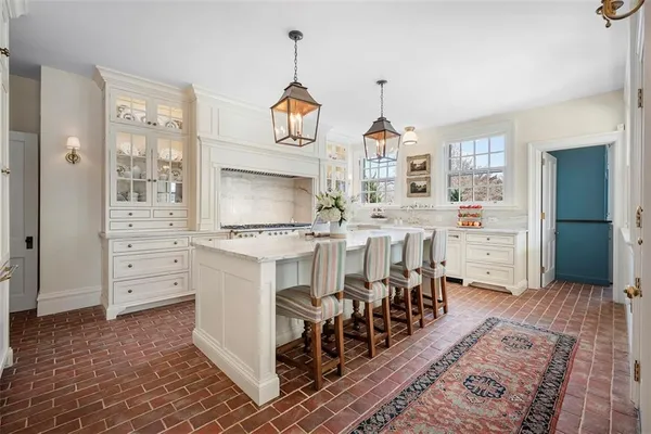 a large white kitchen with wooden floor and a sink