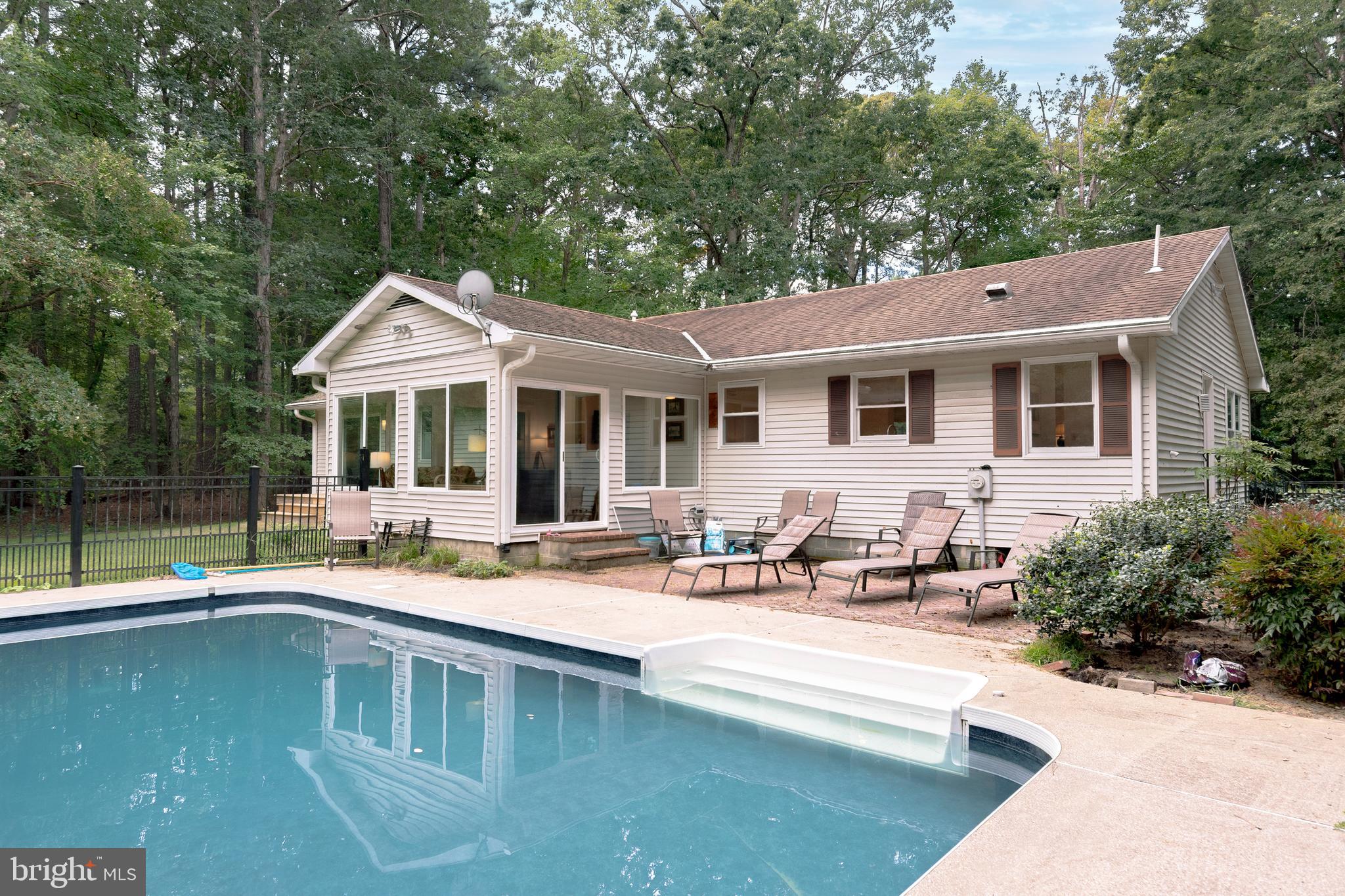 9459 New Road McDaniel, MD 21647 - Photo 5 of 27 a white house with a large pool table and chairs