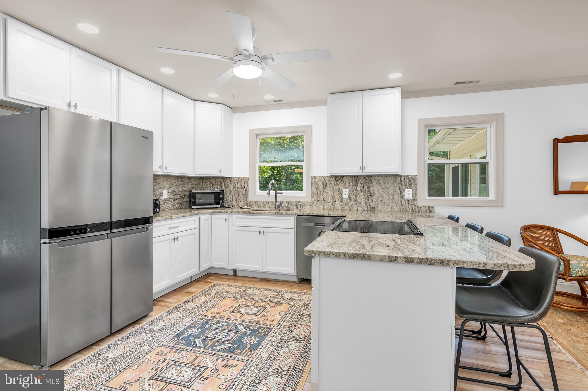 9459 New Road McDaniel, MD 21647 - Photo 7 of 27 a kitchen with a refrigerator a sink cabinets and wooden floor