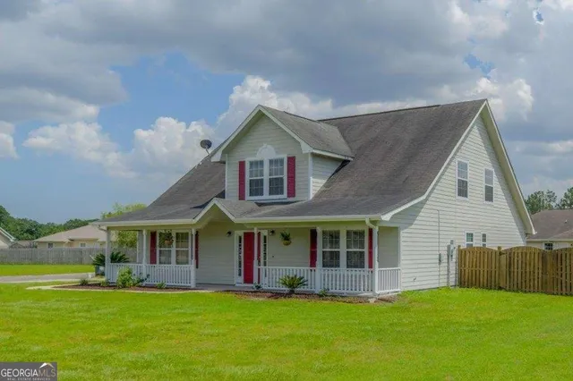 a view of a house with a yard and sitting area