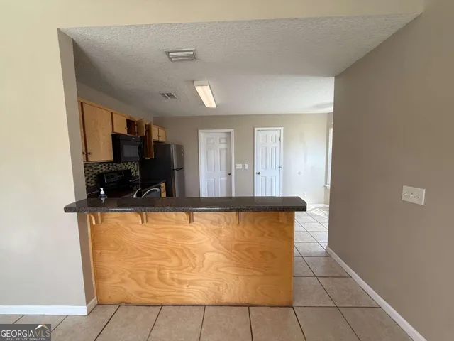 a kitchen with stainless steel appliances a stove a sink a microwave a refrigerator a counter top space and cabinets