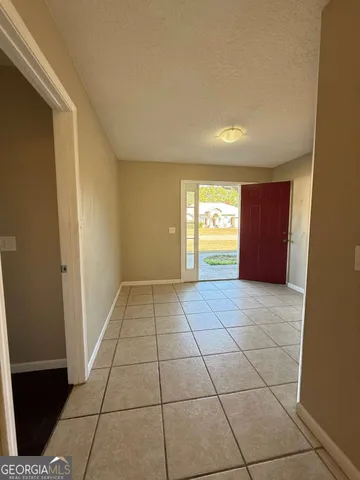 a view of an empty room and window and a kitchen