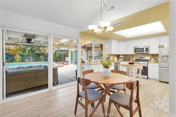 a kitchen with stainless steel appliances granite countertop a dining table and chairs